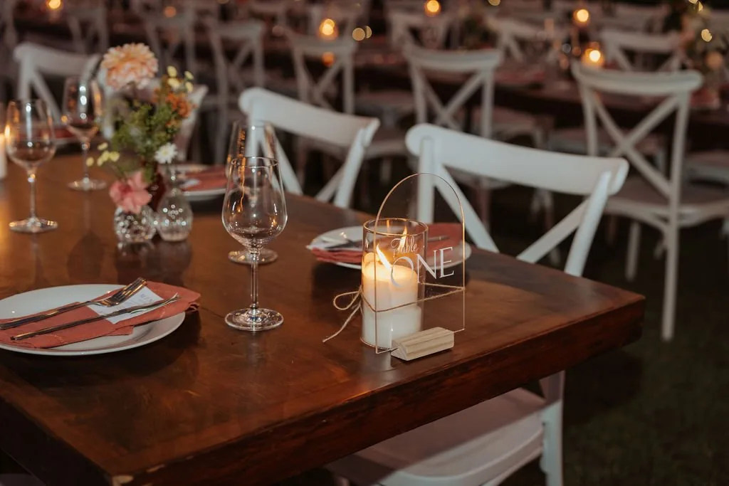 Reception table setting with candlelight, wine glasses and a personalised place card