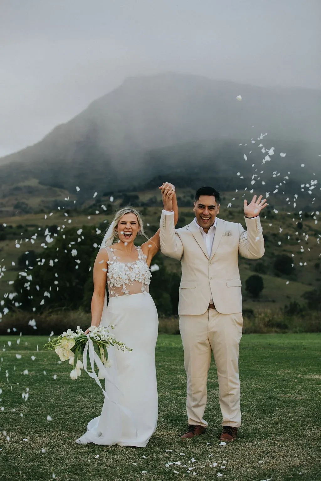 Bride and groom celebrating with confetti falling around them at Maroon Hill Estate